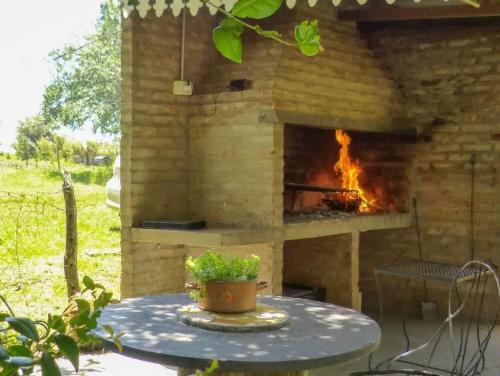 a stone fireplace in a patio with a table at Solar de Campo in Villa Elisa