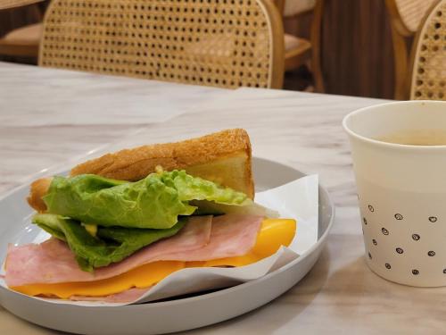 a sandwich on a plate next to a cup of coffee at Hound Hotel Gijang Osiria in Busan