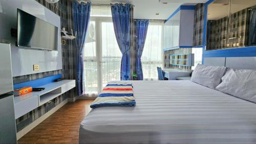 ein Schlafzimmer mit einem großen Bett und einem großen Fenster in der Unterkunft Studio Apartment JiExpo Kemayoran Sunrise View -Min Stay 3 nights- in Jakarta