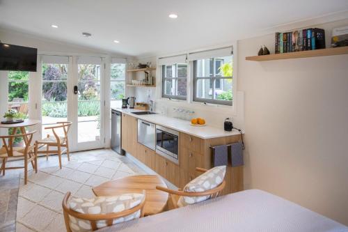 eine Küche und ein Esszimmer mit einem Tisch und Stühlen in der Unterkunft Silk Tree Studio - Steps to Cook Park in Orange