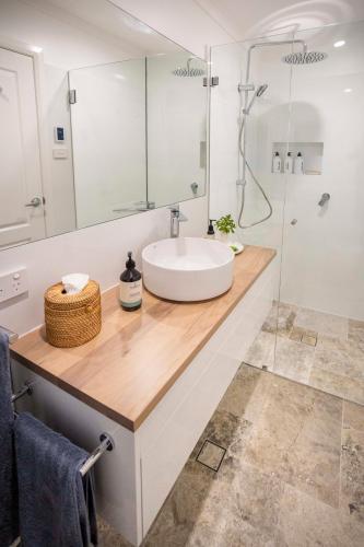 La salle de bains est pourvue d'un lavabo et d'une douche en verre. dans l'établissement Silk Tree Studio - Steps to Cook Park, à Orange