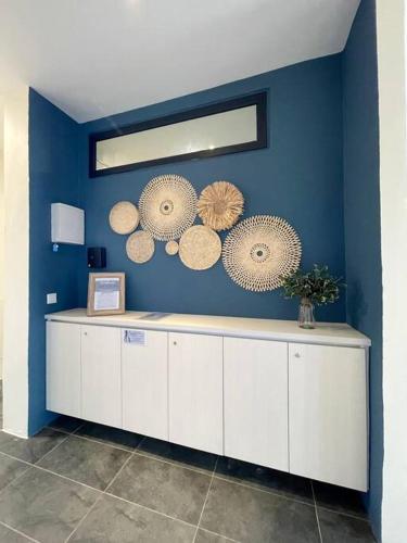 a blue room with a counter with plates on the wall at Roxy Sematan Beach Townhouse Deluxe 3 ,5 & 6 in Sematan