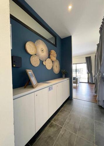 a kitchen with white cabinets and hats on the wall at Roxy Sematan Beach Townhouse Deluxe 3 ,5 & 6 in Sematan