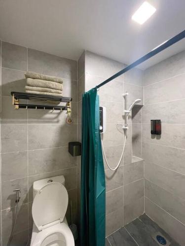 a bathroom with a shower with a toilet and a shower curtain at Roxy Sematan Beach Townhouse Deluxe 3 ,5 & 6 in Sematan
