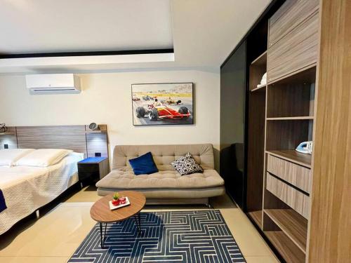 a bedroom with a bed and a couch and a table at Sky Elite Depto de lujo in Santa Cruz de la Sierra
