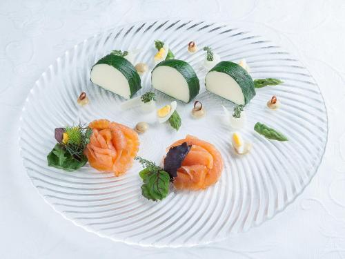 a white plate of food with sushi on it at Gasthof Schopper in Breitenbach am Inn