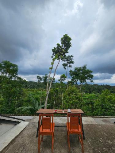 a table and two chairs sitting on a roof at Tetebatu Fullmoon in Tetebatu