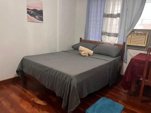 a bedroom with a bed with a teddy bear on it at Bella's Bed & Breakfast in Dauis