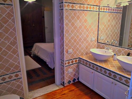 a bathroom with two sinks and a mirror at Villa Giardini in Capoterra