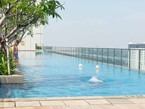 un gruppo di persone in una piscina in un edificio di Luxurious Apartement Lebak Bulus near MRT a Giacarta