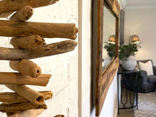 a stack of logs on a wall next to a mirror at The Edward Townhouse 153 - Tastefully Styled in Orange