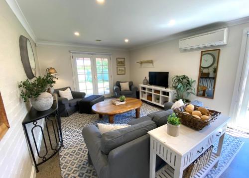 a living room with a couch and a table at The Edward Townhouse 153 - Tastefully Styled in Orange