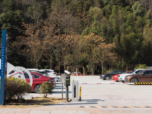 a parking lot with cars parked in front of a mountain at 景德镇树园心舍民宿JDZ Forest Haven B&B in Jingdezhen
