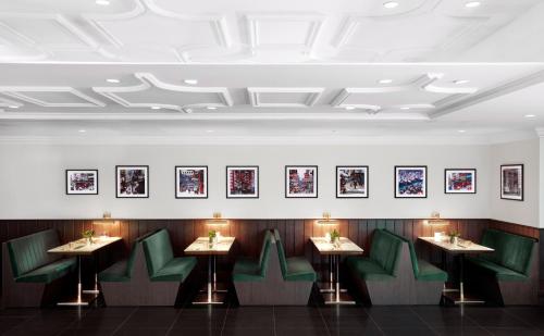 a dining room with green chairs and pictures on the wall at Oasis Aurum 181 Hotel in Hong Kong