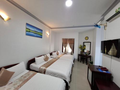 a hotel room with two beds and a table at Du Hung 2 Hotel in Ha Tien