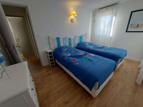 - une chambre avec 2 lits avec des draps bleus dans l'établissement Maison T3 Climatisée à 150m de la Plage avec Terrasse et Parking, Tout à Pied! - FR-1-423-307, au Grau-dʼAgde