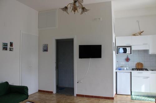 アシェーアにあるLa Terrazza sul Mareのリビングルーム(キッチン、壁掛けテレビ付)