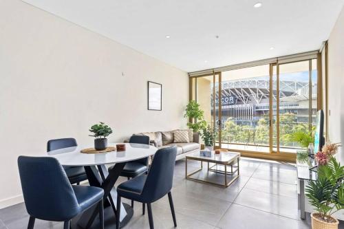 a living room with a table and chairs and a couch at Olympic Park Stadium Cozy 1 bedroom Apt in Sydney