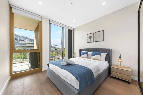 a bedroom with a large bed and a large window at Olympic Park Stadium Cozy 1 bedroom Apt in Sydney