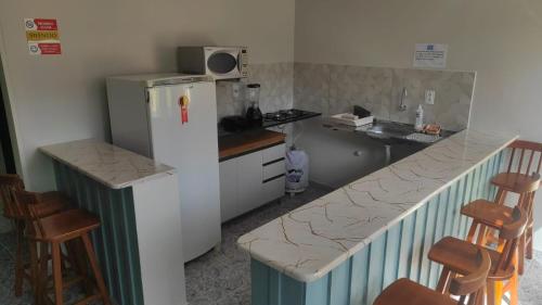 Il comprend une petite cuisine équipée d'un réfrigérateur et d'un comptoir. dans l'établissement Suites Mar Azul, à São José da Coroa Grande