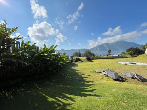 a grassy field with mountains in the background at Bali Camps Park in Kintamani