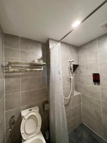 a bathroom with a shower and a toilet in it at Roxy Sematan Beach Townhouse Deluxe 3 ,5 & 6 in Sematan
