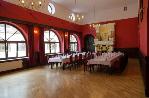 a restaurant with tables and chairs in a room with red walls at Pałac Krobielowice in Kąty Wrocławskie