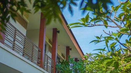 a building with red windows and trees at Dirga's House Sanur View by EPS in Sanur