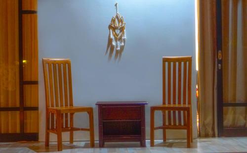 two chairs and a table with a spider on the wall at Dirga's House Sanur View by EPS in Sanur