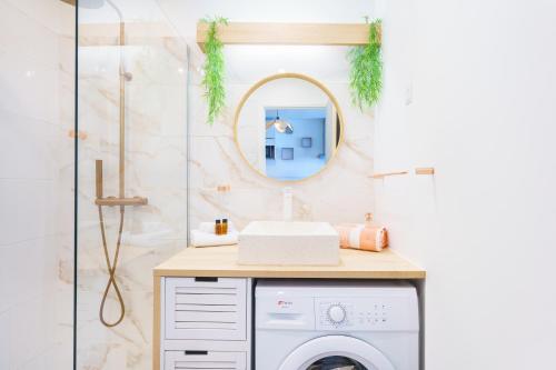 a bathroom with a washing machine and a mirror at Studio neuf et cosy proche des plages - L'Alamanda in Le Gosier