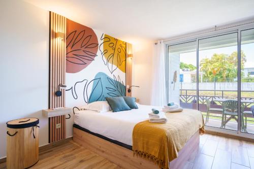 a bedroom with a bed and a balcony at Studio neuf et cosy proche des plages - L'Alamanda in Le Gosier
