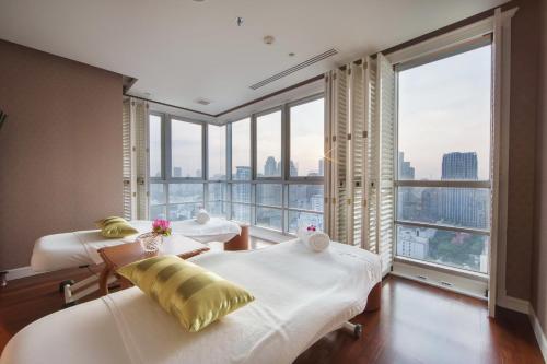 a hotel room with two beds and a large window at Grande Centre Point Ploenchit in Bangkok