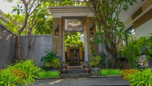 an entrance to a building with a door and trees at Dirga's House Sanur View by EPS in Sanur