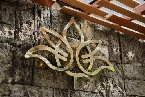 a metal sign on the side of a stone wall at Agastya Ubud Villa in Ubud