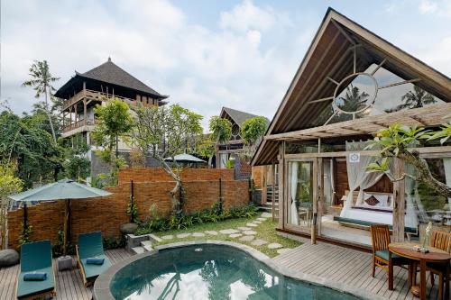 a villa with a swimming pool and a house at Agastya Ubud Villa in Ubud
