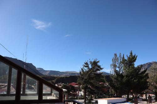 a building with trees and mountains in the background at Sierra Alta Colca in Chivay