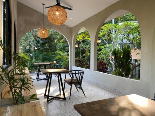 due tavoli e sedie in una stanza con ampie finestre di Mayong Bali Villa and Hostel a Munduk