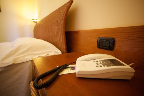a telephone sitting on a table next to a bed at Hotel Orsa Maggiore in Vulcano