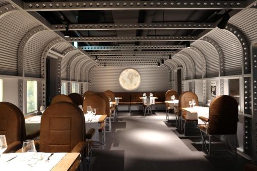 a restaurant with tables and chairs and a clock on the wall at Hotel Cinema 8 in Schöftland