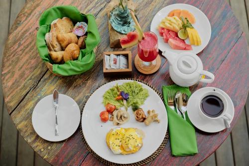 a table with plates of food on top at Agastya Ubud Villa in Ubud
