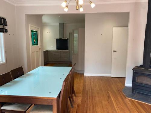 a living room with a table and a fireplace at KK Boarding Holiday house in Hamilton
