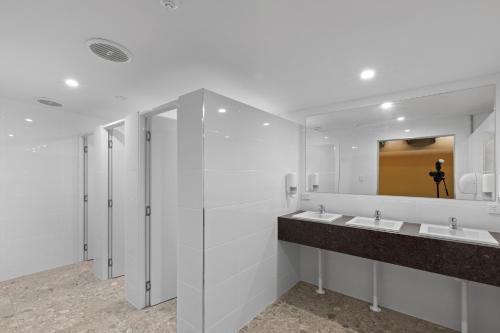 a white bathroom with two sinks and a mirror at BIG4 Adventure Whitsunday Resort in Airlie Beach