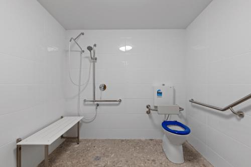 a white bathroom with a toilet and a shower at BIG4 Adventure Whitsunday Resort in Airlie Beach