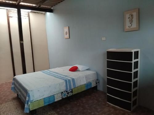 a small bedroom with a bed and a dresser at Arrullos del Mar in Zorritos