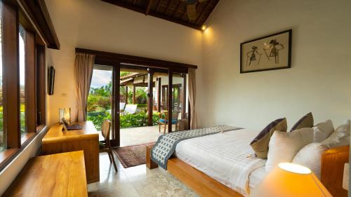 a bedroom with a bed and a view of a garden at Villa Maya Ubud, Peaceful Rice Field View in Ubud
