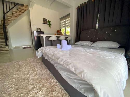 a large bed with white sheets and pillows in a bedroom at Teratak Khalisa in Tanah Merah
