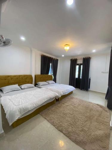 a bedroom with a large bed with a rug at Teratak Khalisa in Tanah Merah