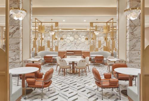 a restaurant with tables and chairs and a lobby at Grand Westside Manila Bay in Manila