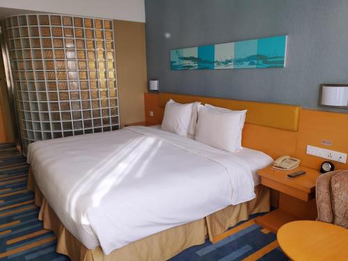 a large bed in a hotel room with a phone at Holiday Inn Express Beijing Airport Zone by IHG in Beijing