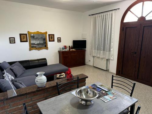 ein Wohnzimmer mit einem Sofa und einem Tisch in der Unterkunft La Vecchia Chiassaia (mare/montagna) in La Pescaia